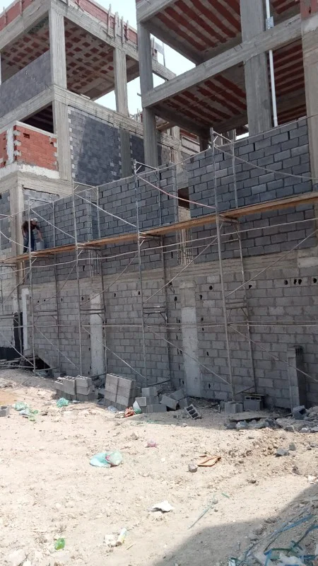 موقع مبنى تحت التنفيذ مع أعمال مباني وتجهيزات إنشائية