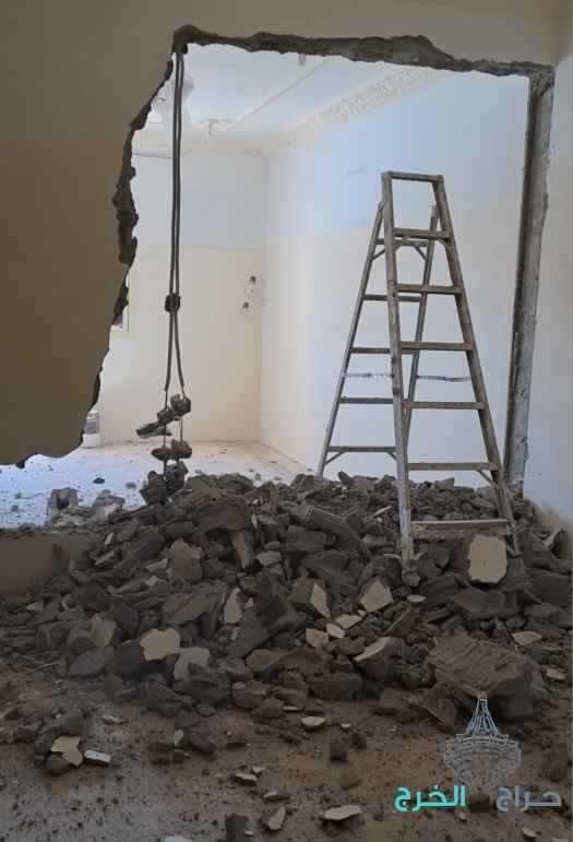 مخلفات هدم متجمعة داخل غرفة بعد إزالة جزء من الحائط